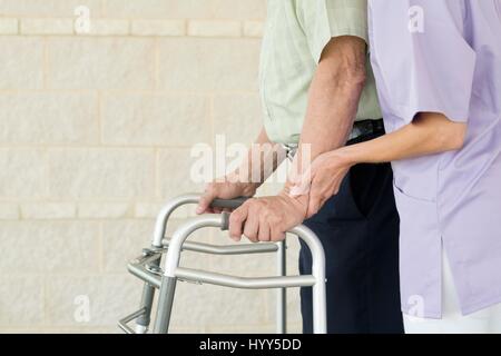 Senior uomo con passeggiate sul telaio di supporto. Foto Stock