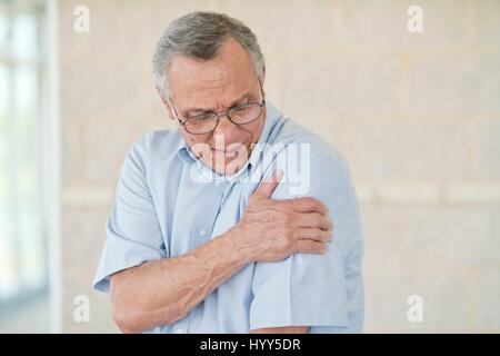 Senior uomo con il suo braccio sinistro nel dolore. Foto Stock