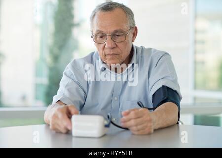 Senior uomo prendendo la sua pressione del sangue. Foto Stock