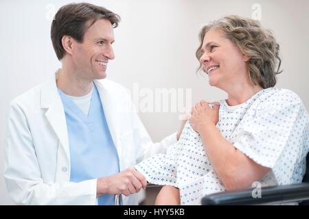Medico maschio sorridente a femmina matura paziente. Foto Stock