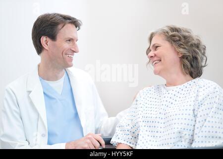 Medico maschio sorridente a femmina matura paziente. Foto Stock