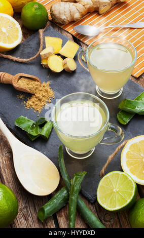 Bere con aloe vera e limoni. Le coppe di vetro su un vassoio di ardesia Foto Stock