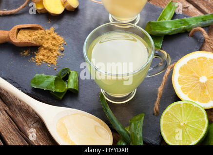 Bere con aloe vera e limoni. Le coppe di vetro su un vassoio di ardesia Foto Stock