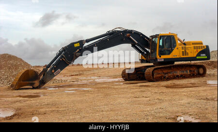 Macchina da scavo nel cantiere nel deserto arabo Foto Stock