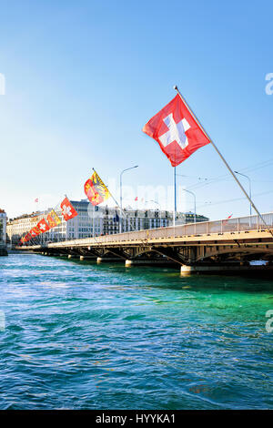 Il Lago di Ginevra e ponte Mont-Blanc con numerose bandiere, Ginevra svizzera. Persone sullo sfondo Foto Stock