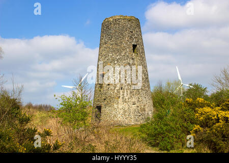 Un vecchio mulino a vento il moncone in un palazzo del XIX secolo le miniere di piombo con le moderne turbine eoliche le palette in background in Conlig Irlanda del Nord. Foto Stock