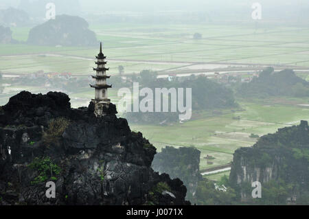 Panorama di campi di riso, rocce calcaree e cima pagoda da appendere Mua punto di vista Tempio in un giorno di pioggia. Ninh Binh, Vietnam Foto Stock