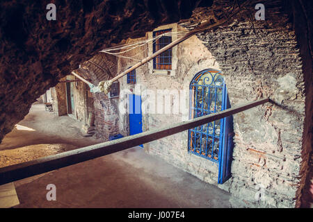 Corridoio con archi e un blu brillante di porte e finestre di un antico edificio caravanserai ad Istanbul, Grand Bazaar area. Pareti in pietra e archi corr Foto Stock