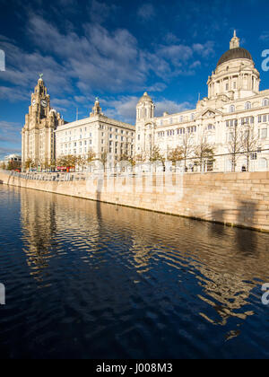 Sole sull'iconico Liverpool docklands waterfront, con il Royal Liver, Cunard e porto di Liverpool edifici. Foto Stock