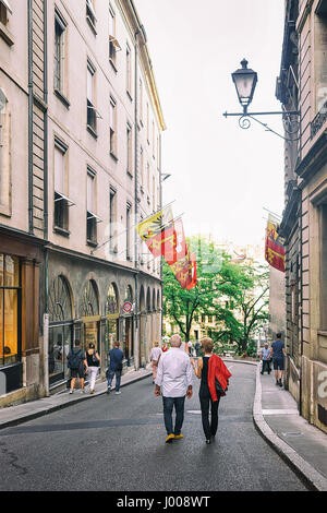 Ginevra, Svizzera - 30 agosto 2016: Senior di persone lungo la strada con le bandiere su Rue de Hotel-de-Ville a Ginevra, città vecchia, Svizzera Foto Stock