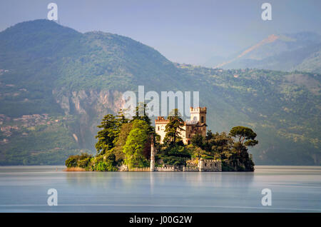 Piccola isola di Loreto sul lago d'Iseo con le montagne sullo sfondo, Italia Foto Stock