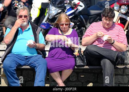 West Bay, Dorset, Regno Unito. 8th Apr 2017. Questi tre visitatori si rinfrescano con un gelato mentre la folla si riverca nella West Bay nel Dorset per godersi quello che sembra il giorno più caldo dell'anno. Credit: Tom Corban/Alamy Live News Foto Stock