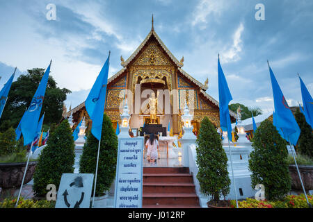 Chiang Mai, Thailandia - Agosto 21, 2016: Donna pregare presso il Wat Phra Singh tempio decorato con Regine bandiere blu su agosto 21, 2016 in Chinag Mai, Tha Foto Stock