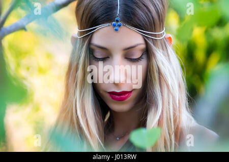 Elf donna in una foresta magica che indossa un pezzo di testa. Soft focus. Foto Stock