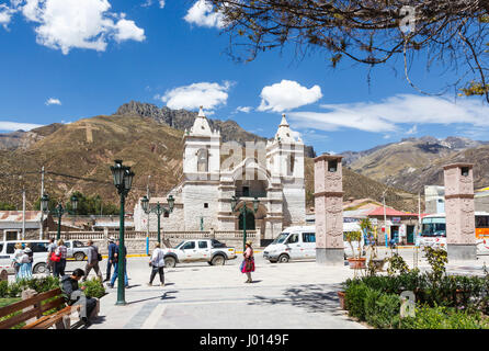 Chiesa con due torri gemelle a Chivay, Colca Valley, capitale della provincia di Caylloma, regione di Arequipa, Perù contro montagne aride con croce hillside Foto Stock