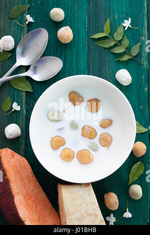 Giapponese di patate dolci gnocco di latte di cocco Thai dessert con piatto laici sullo sfondo di legno Foto Stock