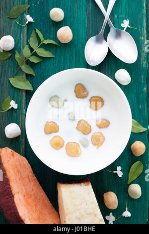 Giapponese di patate dolci gnocco di latte di cocco Thai dessert con piatto laici sullo sfondo di legno Foto Stock