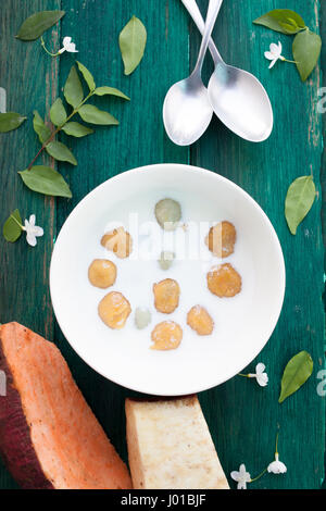 Giapponese di patate dolci gnocco di latte di cocco Thai dessert con piatto laici sullo sfondo di legno Foto Stock