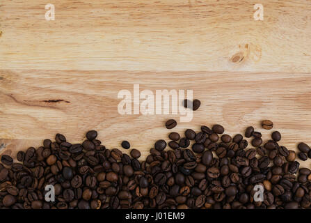 Miscela di diversi tipi di chicchi di caffè su sfondo di legno. Sfondo di caffè Foto Stock