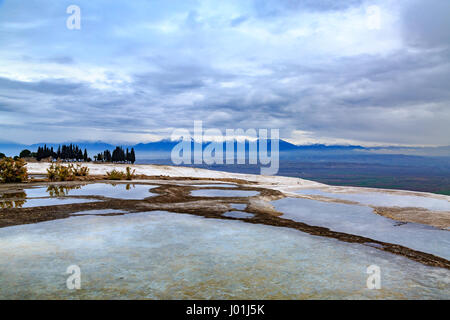 Pamukkale travertini con montagne innevate sullo sfondo Foto Stock