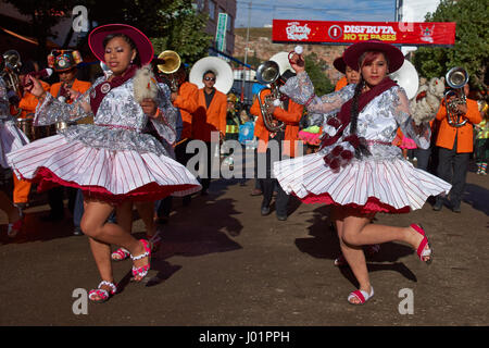 Llamerada ballerini in costumi ornati di eseguire come sfilano attraverso la città mineraria di Oruro sull'altipiano della Bolivia durante il carnevale annuale Foto Stock
