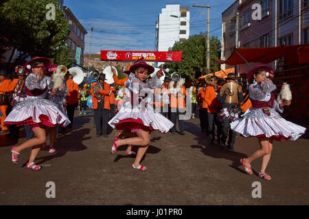 Llamerada ballerini in costumi ornati di eseguire come sfilano attraverso la città mineraria di Oruro sull'altipiano della Bolivia durante il carnevale annuale Foto Stock
