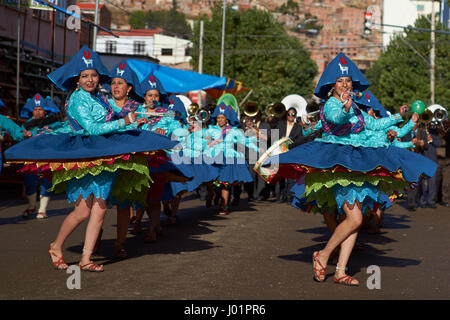Llamerada ballerini in costumi ornati di eseguire come sfilano attraverso la città mineraria di Oruro sull'altipiano della Bolivia durante il carnevale annuale Foto Stock