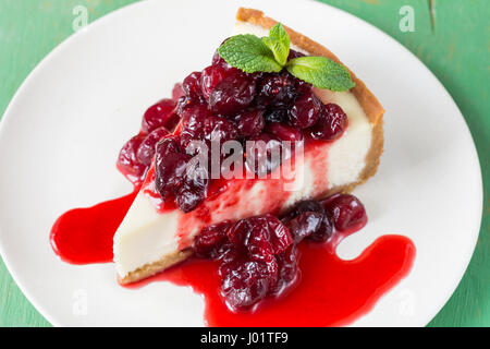 Cheesecake con salsa alle ciliegie sulla piastra bianca, primo piano Foto Stock
