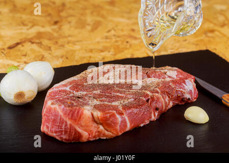 Carne cruda bistecca su pietra scura sullo sfondo pronti per la tostatura Foto Stock