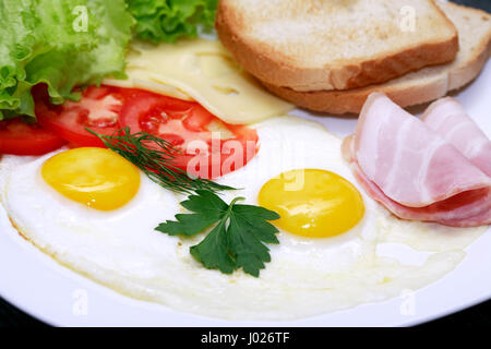 Primo piano della piastra con uova fritte, toast e formaggio Foto Stock