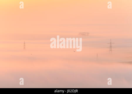 Dorchester Dorset, Regno Unito. Il 9 aprile 2017. Gloriosa misty sunrise nitido su West Dorset e Dorchester visto da Hardy Monument al di sopra della nebbia fitta e nebbia. Con pochi alberi e tralicci al di sopra della nebbia. Le condizioni di nebbia sono impostati per cancellare per una luminosa e soleggiata giornata attraversando il paese con temperature prevista per essere 24ºC in alcuni luoghi del Regno Unito © DTNews/Alamy Live Foto Stock