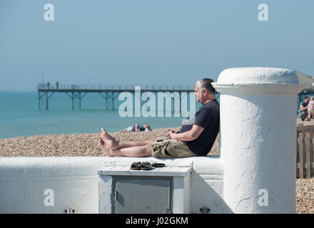 Un uomo gode il sole sulla spiaggia a Bognor Regis, West Sussex, in Inghilterra. Foto Stock