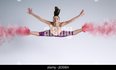 La donna nel salto in studio e effetto di disintegrazione Foto Stock