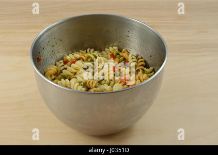 Rotini vegetale insalata di pasta con erbe aromatiche spezie condimento per insalata in acciaio inox recipiente di miscelazione Foto Stock