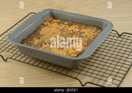 Brownie con la caramella pezzi dentro e come condimento caldo fuori del forno sul raffreddamento per rack Foto Stock