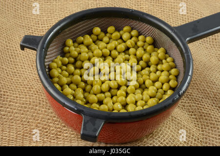 Conserve di piselli dolci svuotamento del filtro in un recipiente a basso contenuto di sale Foto Stock