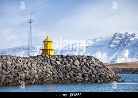 Giallo Torre Faro sulla scogliera di pietra, ingresso a Reykjavik porto industriale Foto Stock