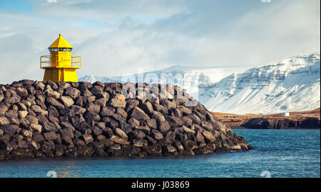 Giallo Torre Faro sulla scogliera di pietra, ingresso a Reykjavik porta di carico. Vintage foto dai toni, retro foto effetto filtro Foto Stock