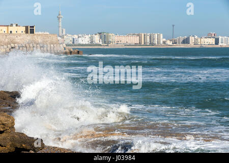 Le onde battono le rocce sul lungomare di La Caleta Beach a Cadiz, Spagna Foto Stock