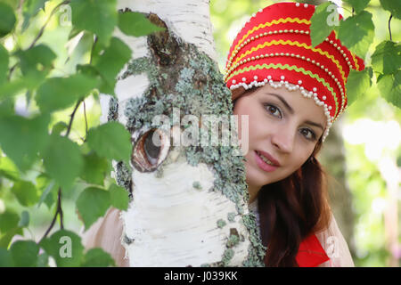 Gli slavi in abito tradizionale di nascondersi dietro gli alberi Foto Stock