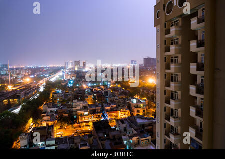 Noida cityscape di notte con le case, ufficio, grattacieli, strade e rotaie della metropolitana visibile. Un sacco di costruzione è visibile come bene che mostra lo sviluppo Foto Stock