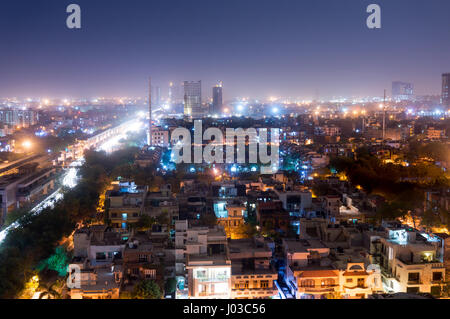 Noida cityscape di notte con le case, ufficio, grattacieli, strade e rotaie della metropolitana visibile. Un sacco di costruzione è visibile come bene che mostra lo sviluppo Foto Stock