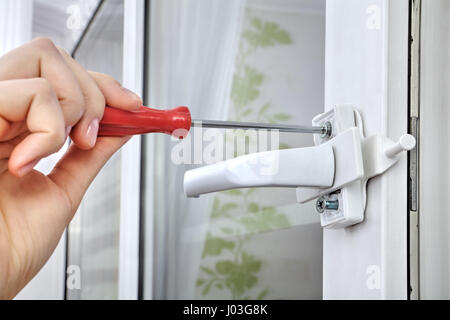 Installazione del limitatore di efflusso nella finestra di windows, usando le mani, close-up. Foto Stock