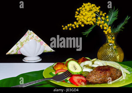 Kebab macinata di maiale con verdure su tavolo e su sfondo nero Foto Stock