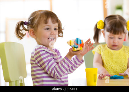 I bambini la creatività. Kids scolpire da argilla. Simpatici ragazzi piccoli lo stampo da plastilina sul tavolo in camera Foto Stock