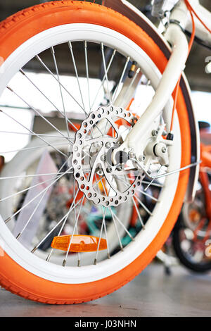 Bianco Arancione bicicletta nel negozio di biciclette. Vista frontale Foto Stock