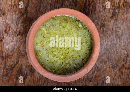 Tradizionale polacco sour gherkin Zuppa servita in un vaso di argilla. Foto Stock