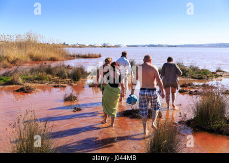I turisti prendere bagni di fango nel lago rosa di Torrevieja, Parque Natural de las Lagunas de La Mata y Torrevieja, Spagna Foto Stock