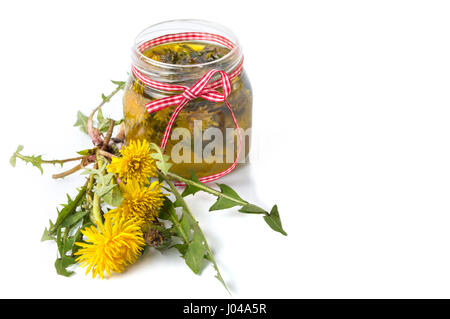 Fiori di tarassaco e l'olio in un recipiente isolato Foto Stock