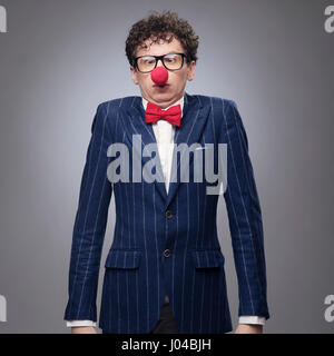 Imprenditore divertenti indossando red clown naso Foto Stock